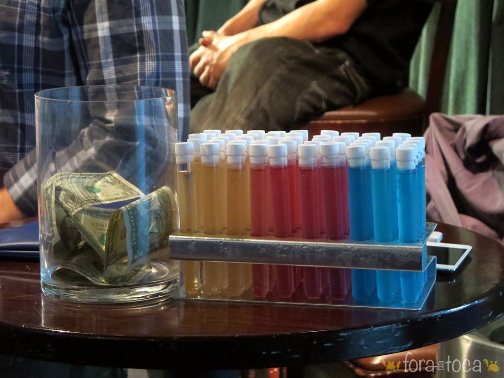 table in detail, glass pot with tips and colorful tequila shots in test tube