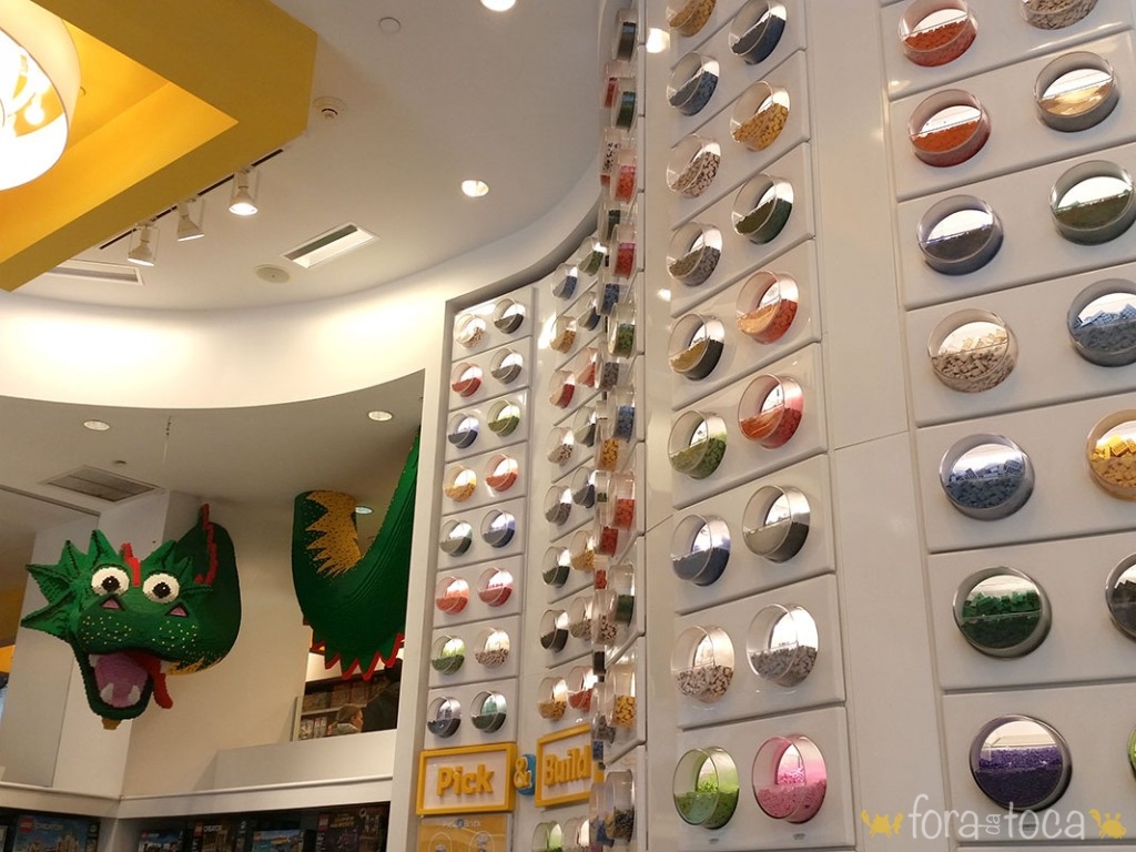 parede de peças avulsas na Lego store, detalhe do dragão verde de lego ao fundo